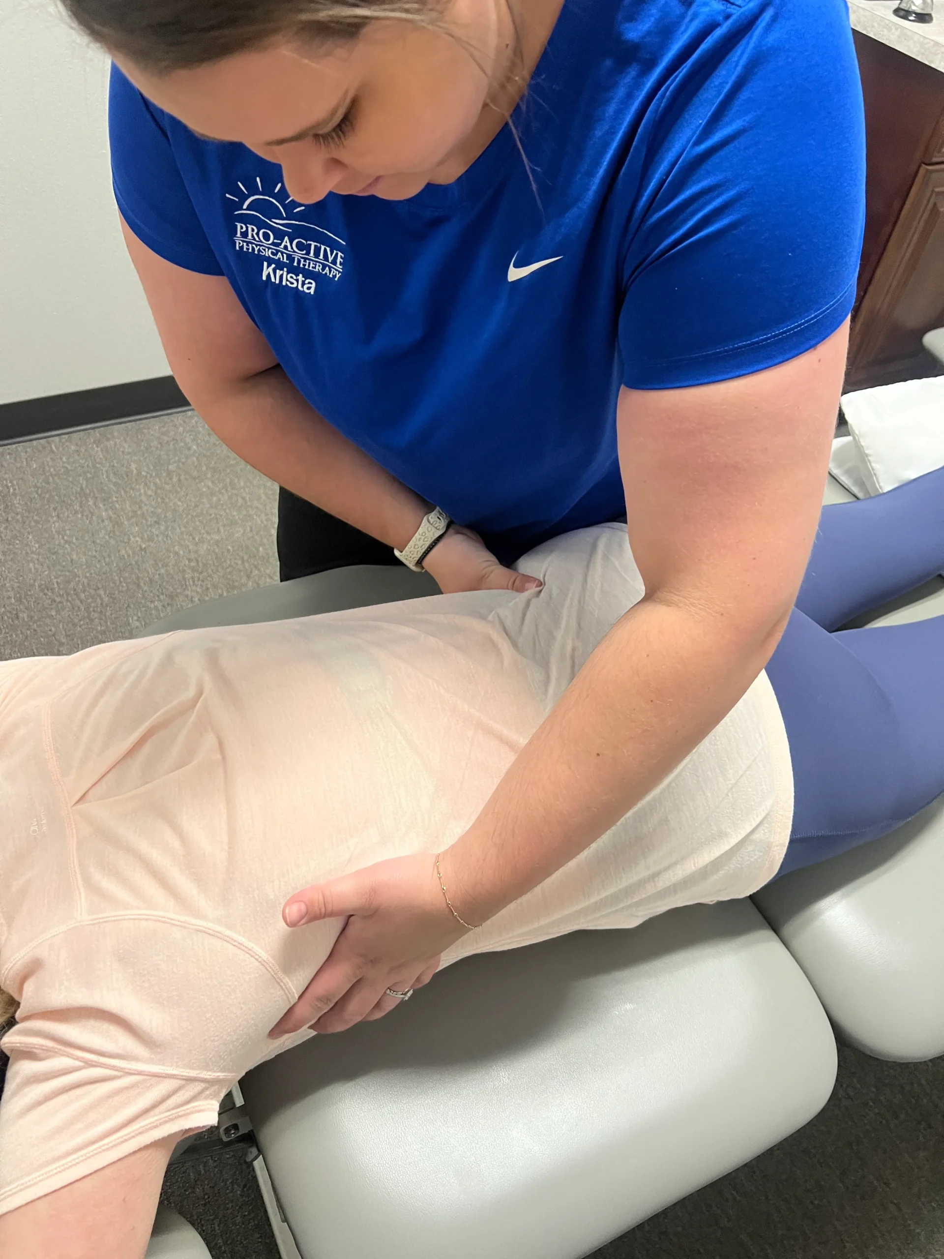 physical therapist at Pro-Active Physical Therapy examining her patient's lower back